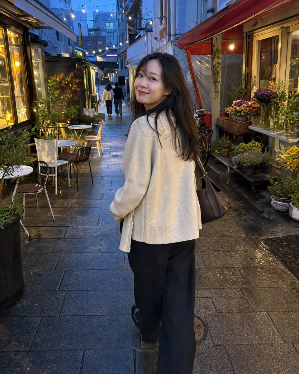 Generated image of a woman turning toward the camera in a café alley at dusk